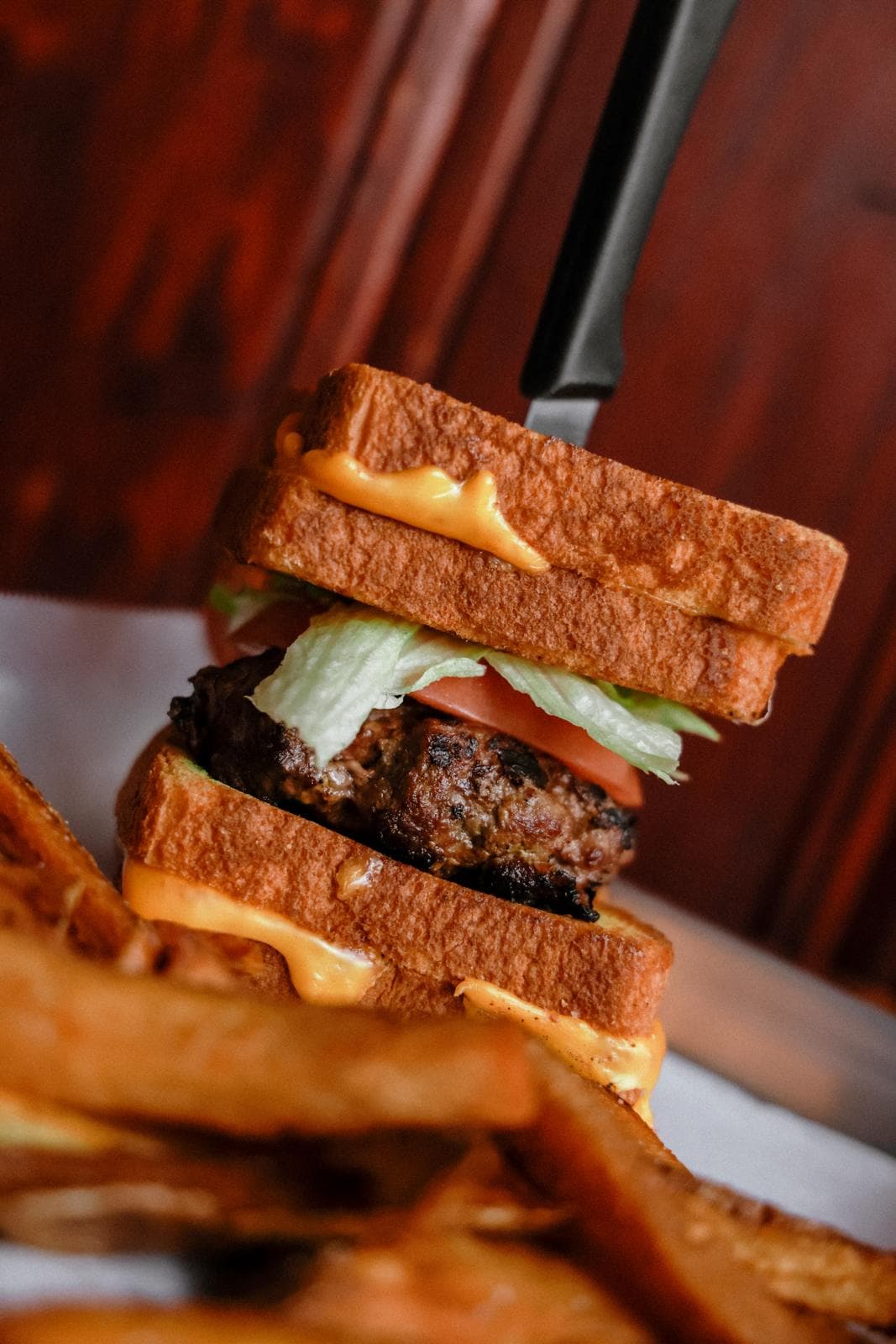 The Village Idiot: a burger between two grilled cheese sandwiches, with fries